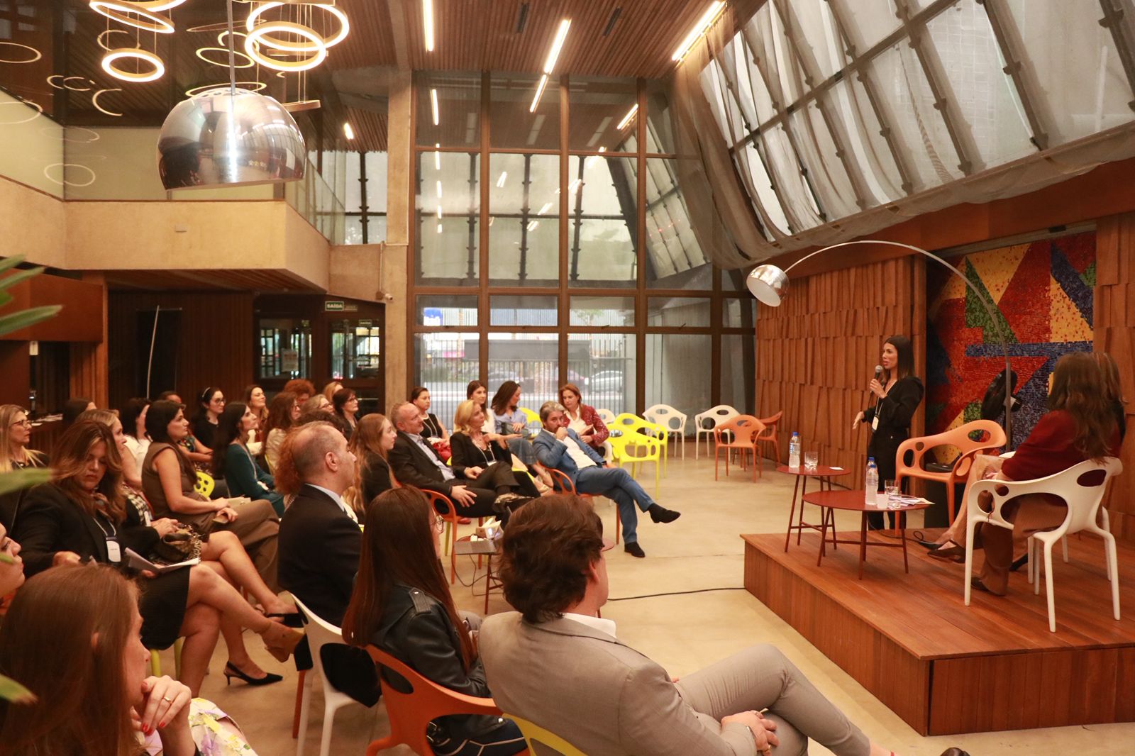 Luana Uchôa palestrando para uma plateia em evento corporativo